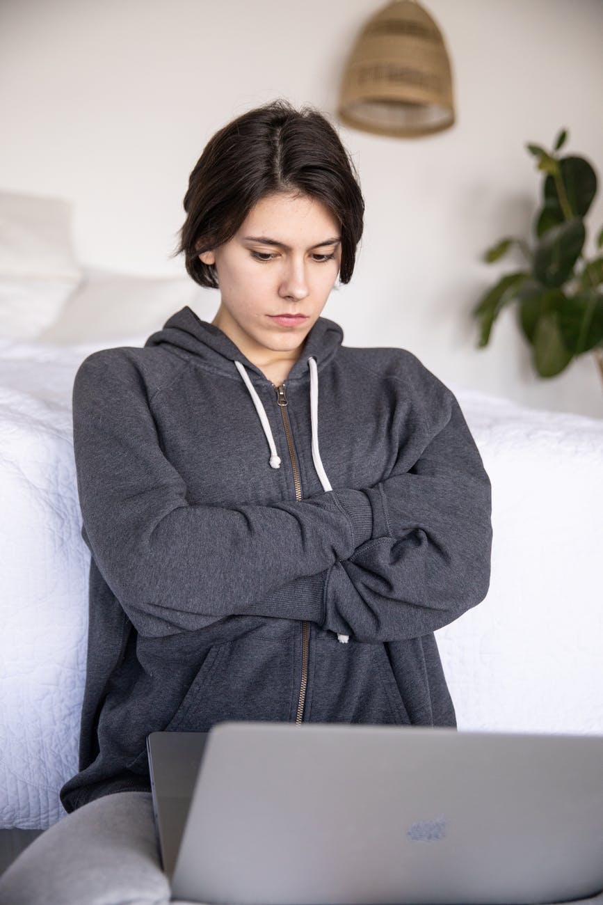 Female looking troubled in front of a laptop.
