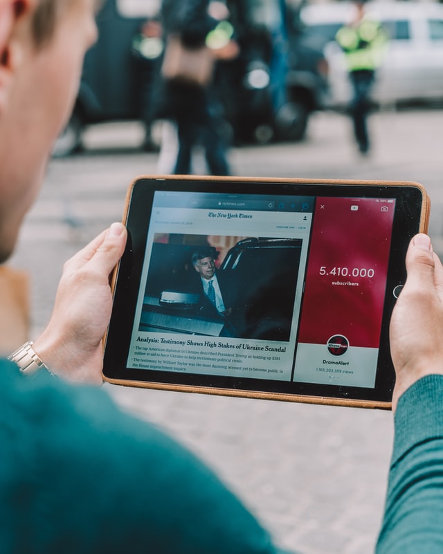 Man holding an ipad, reading The New York Times in split screen mode