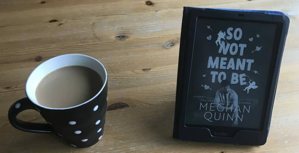 Photo showing a coffee cup and a Kindle standing on a table