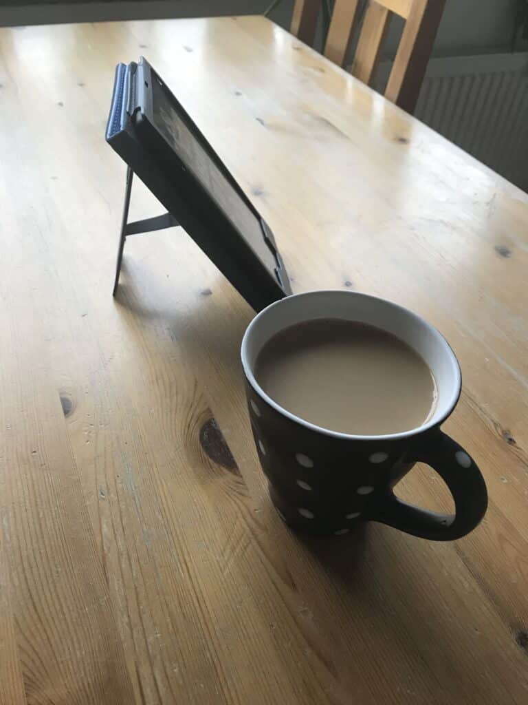 Photo showing a coffee cup and Kindle seen from the side