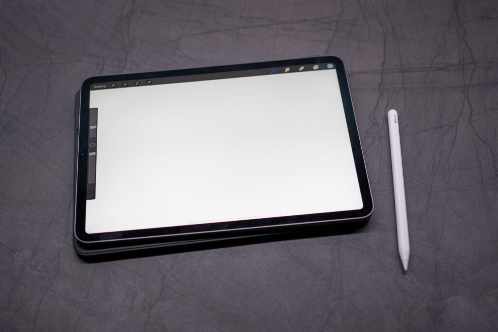Image showing an ipad and Apple pencil on a dark gray background.