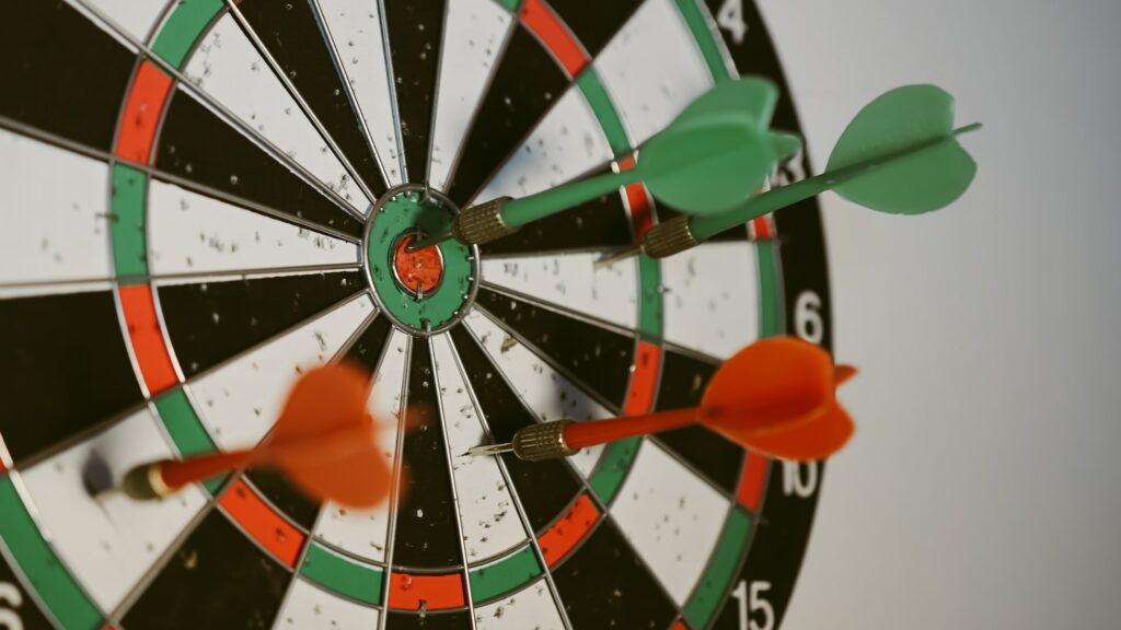 A close-up of a dartboard, on dart hit the center goal.