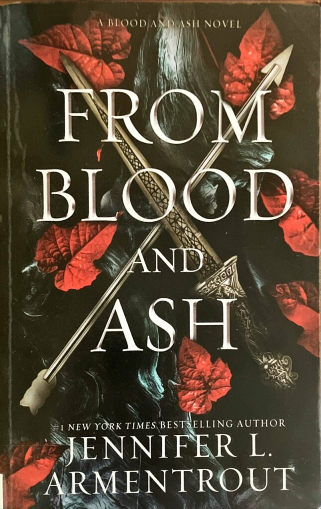 Image showing the front cover of the novel From Blood and Ash. The picture shows the title of the novel and you can see a dagger and an arrow forming a cross, with read leaves in the background.