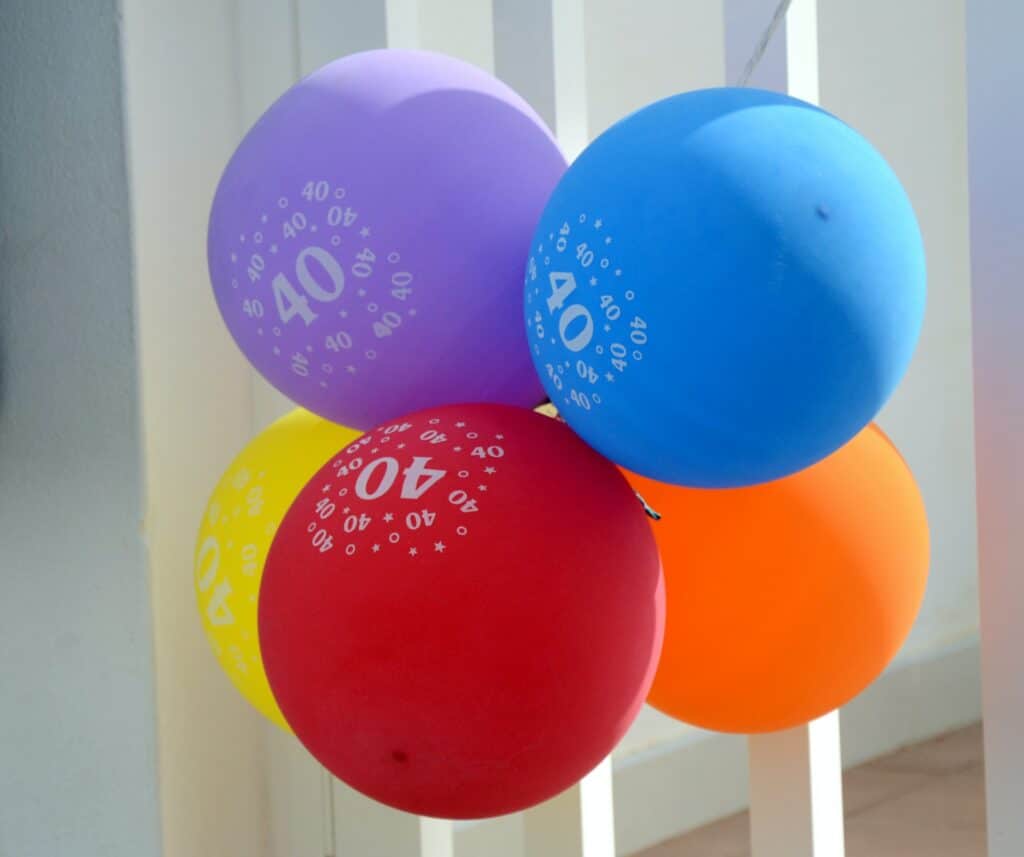 A bunch of balloons with the number forty on them.