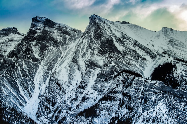 Photo of snow covered mountains under blue sky.