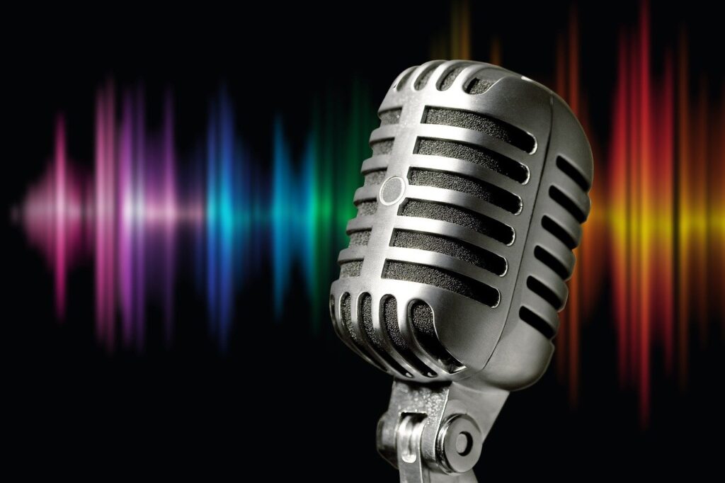 Image of a classic microphone on a black background with colours looking like soundwaves.