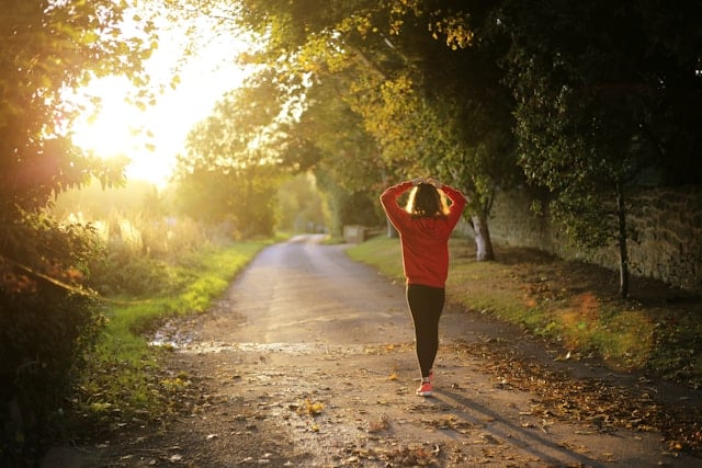 Image of a woman walking on a pathway during daytime.