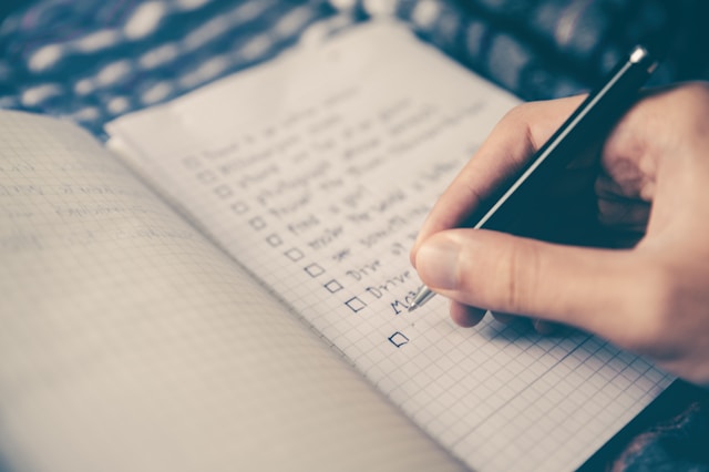 Person writing a bucket list to beat procrastination